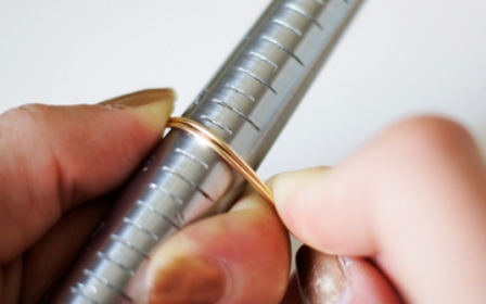 Bước 3: Quấn sợi đồng đôi vừa gập xung quanh ống tròn. Lưu ý: uốn tại nơi vừa với size nhẫn nhé!