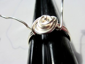 Bước 5: Lồng nhẫn vào khuôn ống, dùng kìm uốn các đầu kẽm bám sát vào thân nhẫn. Bạn được vòng kẽm thứ nhất.